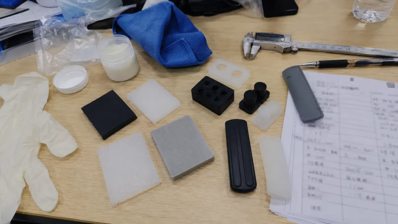 Phone photo of TPE and silicone samples checked on a product comparison desk
